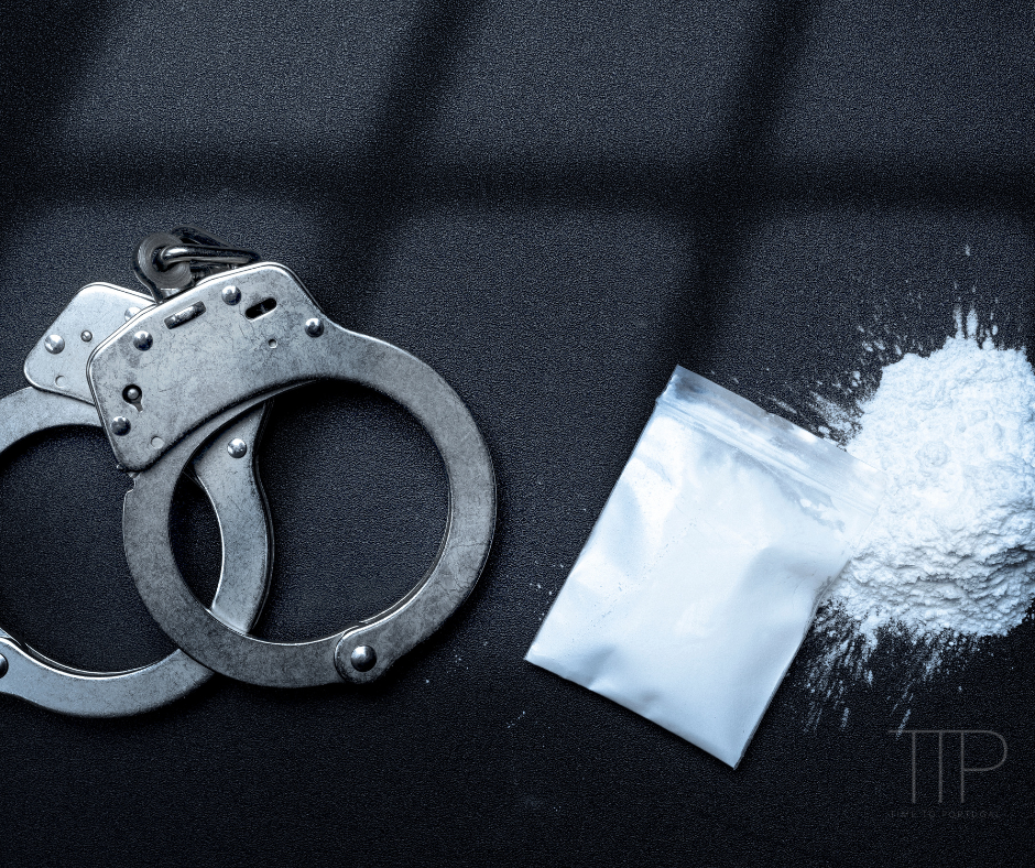 handcuffs and bag of cocaine on black table