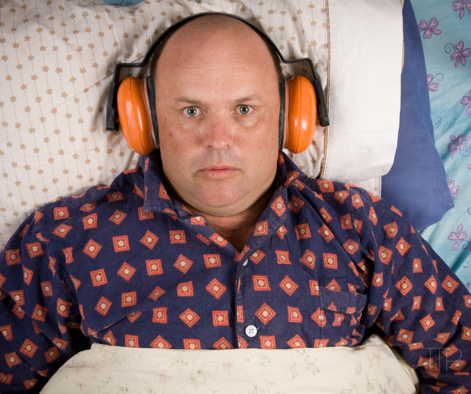 man with ear protection in bed