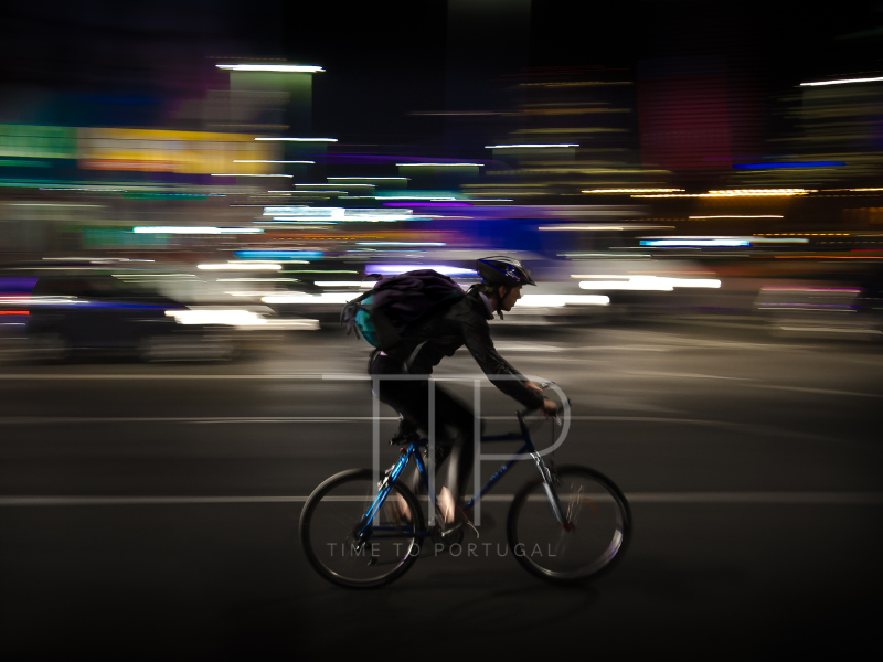 man on bicycle in city at night