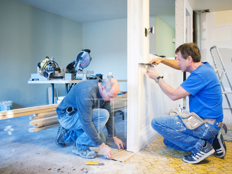Two men doing repairs in a house