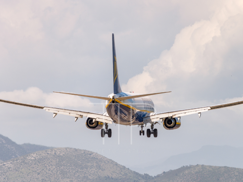 a plane flying with mountain tops in background