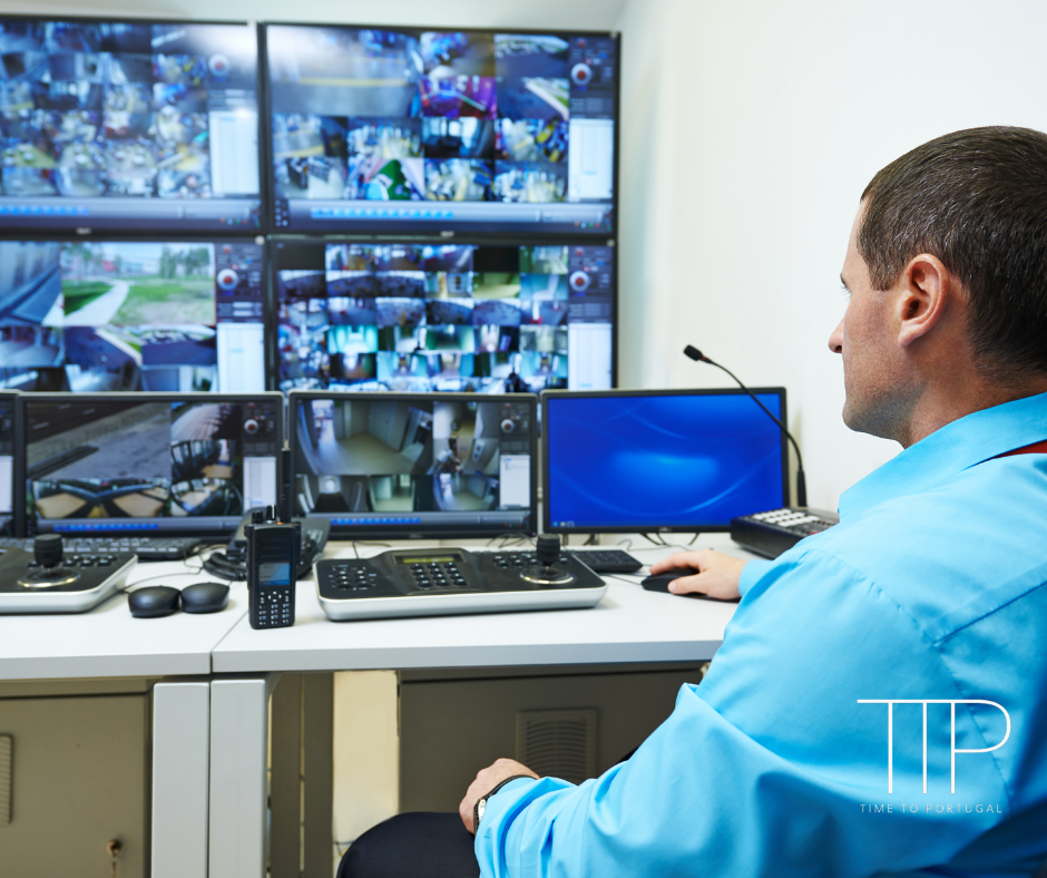 man at desk with surveillance images on screen