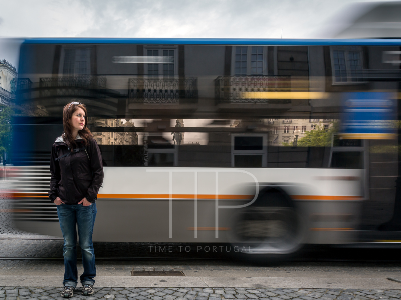 Woman standing in front of a bypassing bus