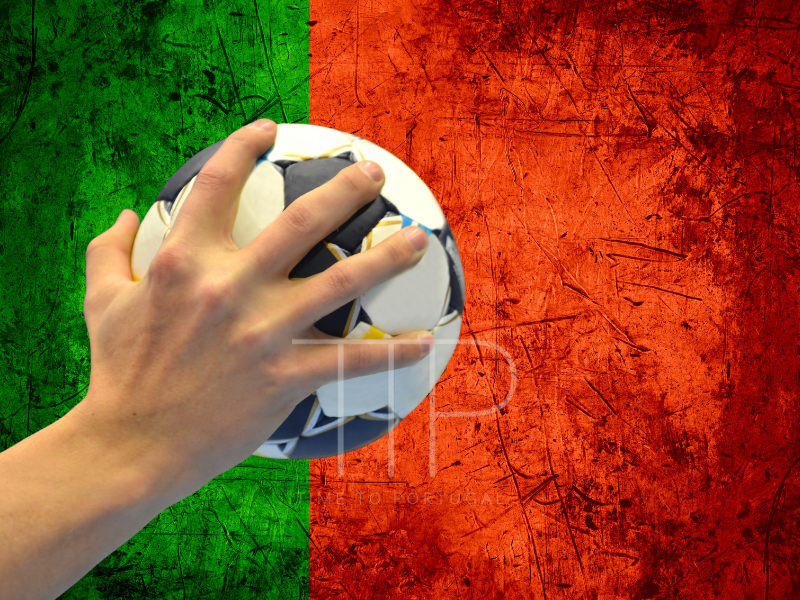 A hand holding a handball with the Portuguese green and red colors in backround