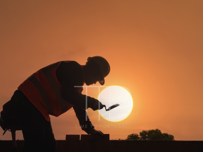 A man working construction with sunset in background