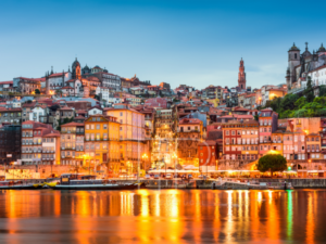 A city at a waterfront after sunset with shining lights.