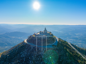 A stone fortress on top of a hill with landscape background.