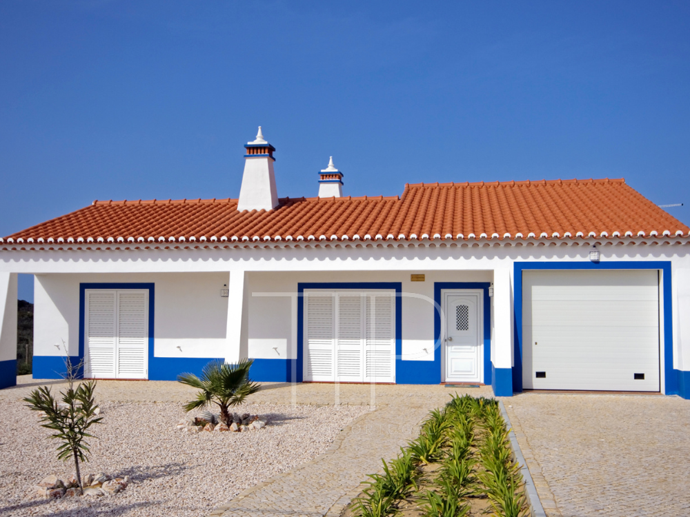 white and blue painted house in front of blue sky