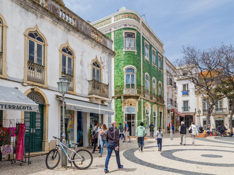 people in a street with older colorful buidings