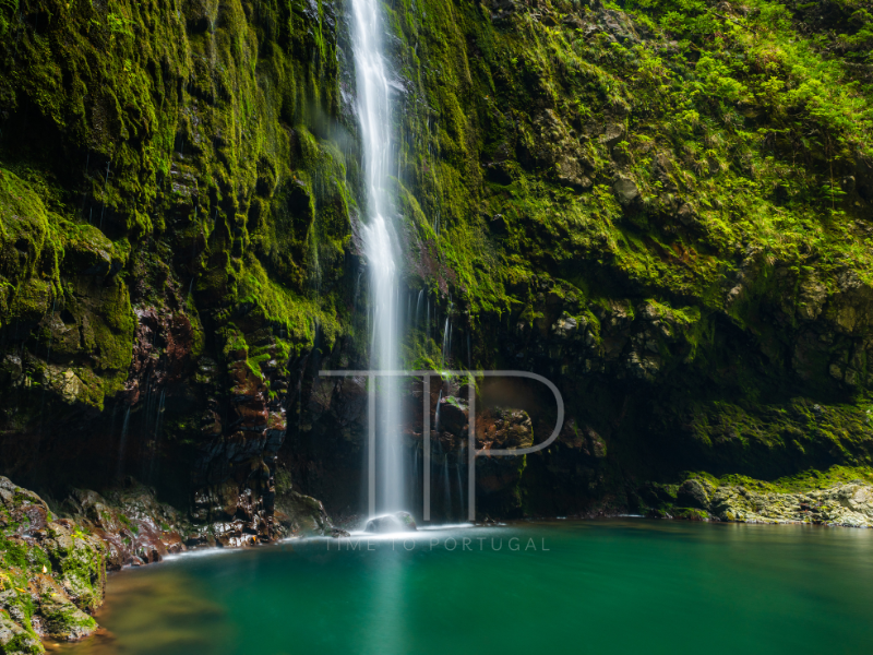 waterfall with green rocks in back