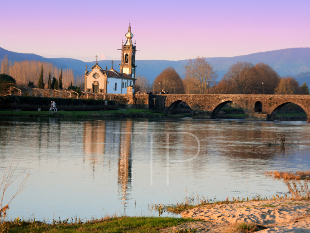 river with bridge and a church in back